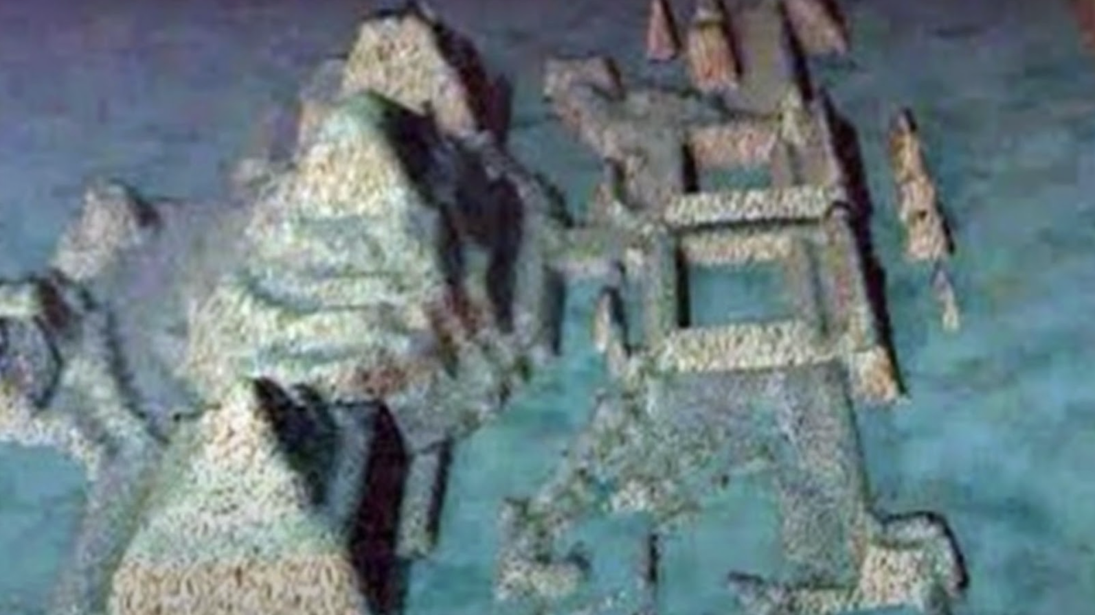 An underwater image showing stone formations that appear to be arranged in a symmetrical pattern, resembling the ruins of an ancient architectural complex